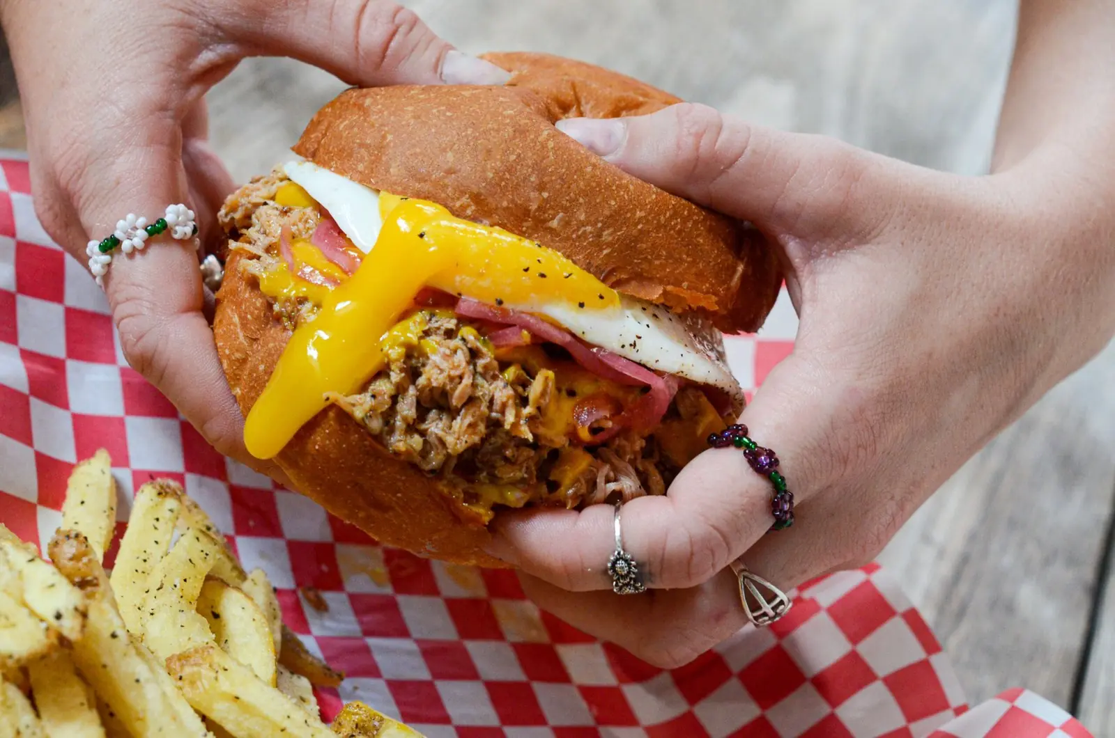 Smoked pulled pork sandwich in hand